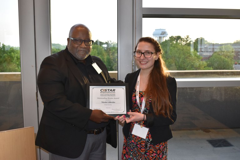 EWD Co-Director Mike Harris presenting an award to graduate student Nicole Libretto for excellence in Mentoring